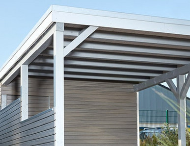 Carport mit Holzdach als Unterstand für ein geparktes Auto.