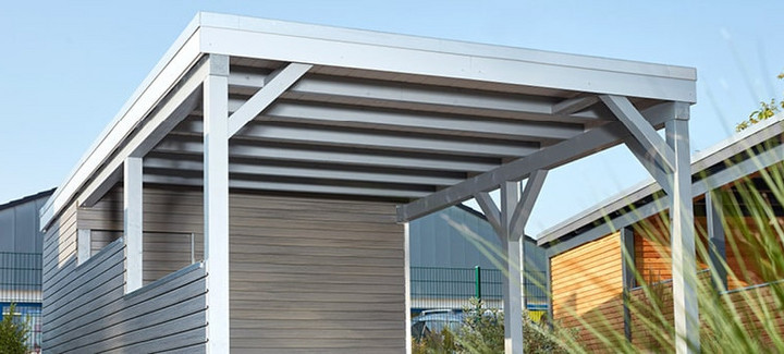 Carport mit Holzdach als Unterstand für ein geparktes Auto.