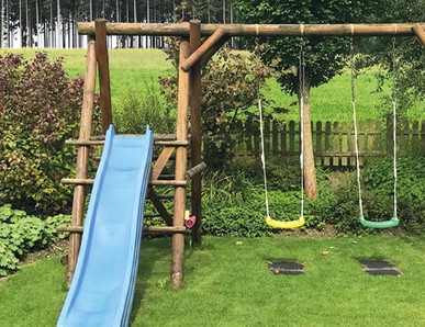Spielgeräte: Schaukel und Rutsche für Kinder im Garten.